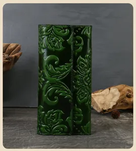 Detailed closeup shot of the dark green embossed leather trifold wallet with floral patterns.