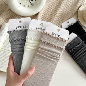 Detail shot of autumn winter solid color ruffle mid tube socks stack socks comfortable cotton style.