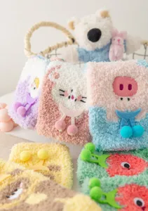 Thickened coral fleece socks with cute cartoon animal embroidery and fluffy pom-pom details.