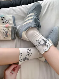 Cute cartoon cat mid-tube socks for women with bowknot and pompom details, comfortable cotton.