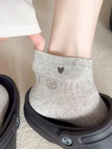 Detail shot of breathable grey ankle socks featuring cute heart embroidery and mesh cutout design.