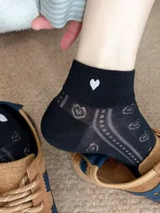 Detail view of women's black sheer hollow heart socks, breathable spring summer ankle socks.