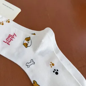 Detailed close-up of white cute puppy pattern cotton mid-tube socks, adorable design.