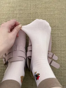 Close-up detail of white cute dachshund cotton socks, showing stretchy ribbed fabric texture.