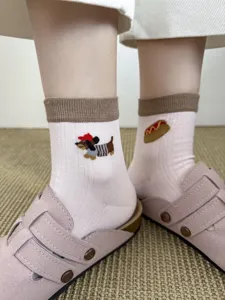 Detailed view of cute cartoon dachshund and hotdog embroidered cotton socks for women.