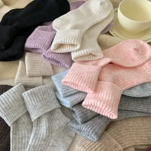 Detailed view of cozy winter wool thermal socks in various pastel colors stacked nicely.