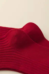 Close-up detail of soft red ribbed cotton socks showing fine knit texture and quality fabric.