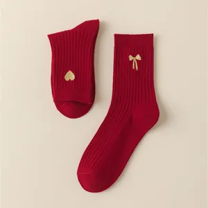 Red cotton mid-calf socks with gold embroidered heart and bow details for women and girls.