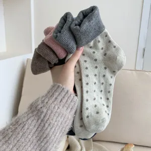 Close-up detail shot of thick thermal women winter socks with cute dot patterns and cozy cuffs.