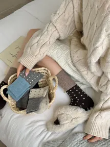 Cozy knit wool socks detail featuring cute polka dot patterns and warm winter styling.