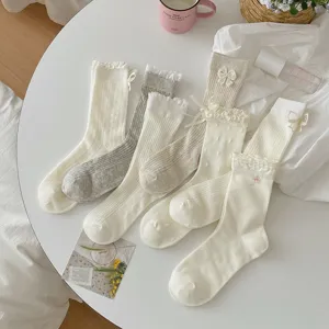 Cute Japanese style white and grey mid-tube socks with lace trim and bows for women.