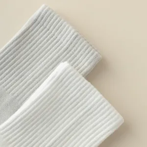 Detailed close-up of ribbed yoga socks in grey and white colors, showing soft knit texture.