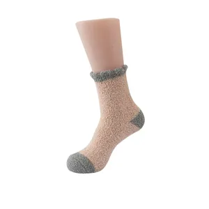 Nahaufnahme von kuscheligen dicken Wintersocken aus Frottee in Rosa mit grauen Akzenten.