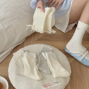 Detailed shot of Japanese ballet style women mid-calf socks with delicate lace and bows.