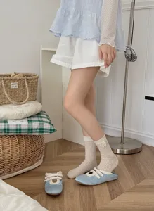 Detail shot of beige ribbed women mid calf socks featuring a sweet cute bow accent accessory.