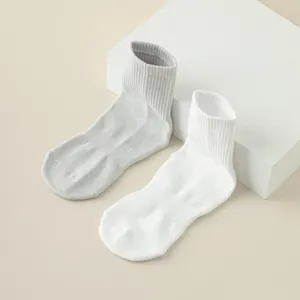 Close-up detail of soft mid-calf women's socks in gray and white with ribbed cuffs.
