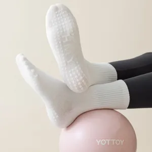 White grip socks detail view, featuring anti-slip silicone dots on sole for yoga and pilates.