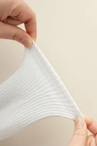 Close-up detail of white ribbed yoga socks showing excellent stretch and fabric texture.
