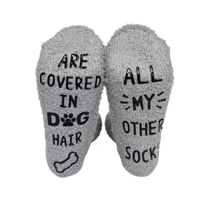 Close-up detail of fluffy grey fuzzy novelty socks featuring funny non-slip letter soles.