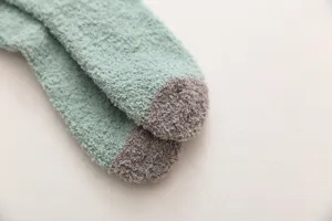 Nahaufnahme von flauschigen Wintersocken, weiches Fleece, mintgrün und grau für gemütliche Tage.