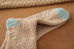 Close-up detail of soft coral fleece cozy winter sleep socks with anti-slip grip sole.