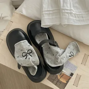 Black Mary Jane shoes with cute bow heart grey socks detail shot showing aesthetic style.
