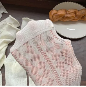 Vue détaillée de chaussettes mi-mollet en résille blanche avec motif argyle pour l'été.