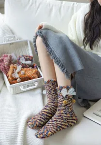 Cozy fuzzy coral fleece winter socks for women with cute ribbon bow and warm floor design.