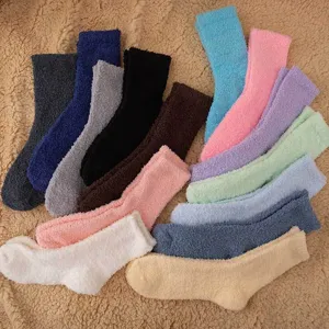Detailed view of assorted soft fuzzy coral fleece socks in multiple solid colors for winter warmth.