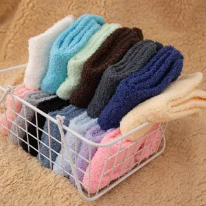 Detail shot of cozy coral fleece winter socks in assorted solid colors inside a white wire basket.