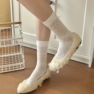 Close-up view of women white mesh hollow bow socks and floral decorative shoes in a clean room.