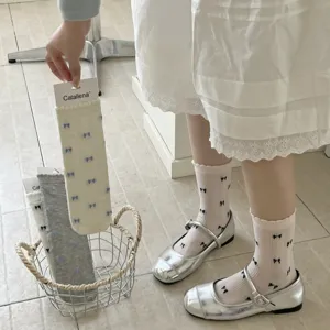 Primer plano de calcetines de rejilla con lazos, volantes delicados y estilo de verano transpirable.