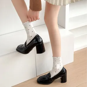 Detail shot of cute women's mid-tube socks with polka dots and ruffled lettuce edge.