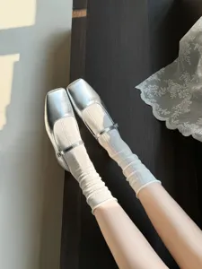 Vue détaillée de chaussures Mary Jane argentées élégantes avec chaussettes blanches respirantes.