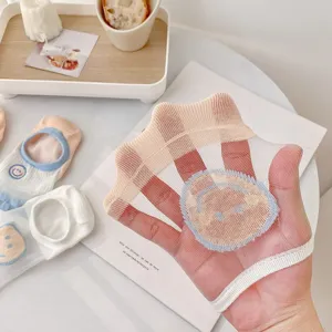 Detailweergave van transparante zomersokken van fijne mesh met schattig borduurwerk.
