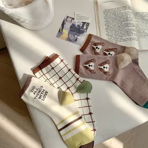 Detail view of cute women's cotton mid-calf socks featuring adorable puppy and plaid patterns.