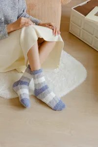 Close-up of cozy striped coral fleece floor socks in soft pastel tones for winter comfort.