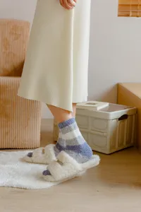 Close-up detail of women's autumn winter thick striped coral fleece sleep socks fuzzy slip.