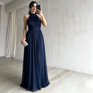 Detalle del vestido de noche azul oscuro sin mangas con una falda larga fluida y elegante.