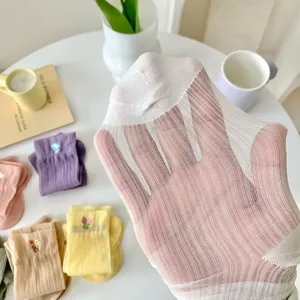 Detailed view of sheer translucent mesh crew socks, breathable summer thin hosiery display.