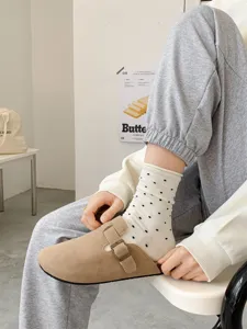 Classic suede clogs mules paired with cute polka dot socks, comfortable daily footwear style.