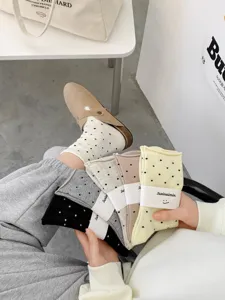 Close-up detail of cute polka dot socks with rolled cuffs, soft fabric and multi-color styles.