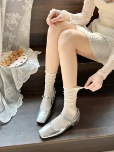 Chaussettes montantes fines ajourées pour femmes avec chaussures Mary Jane argentées style respirant.
