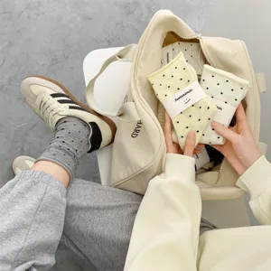 Japanese style polka dot cotton mid-tube socks with rolled cuff and card packaging.