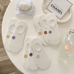 Gedetailleerde close-up van witte dames sneakersokken met leuke smiley printjes.
