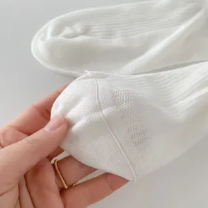 White cotton mesh socks detail close up showing breathable fabric and fine knit texture.