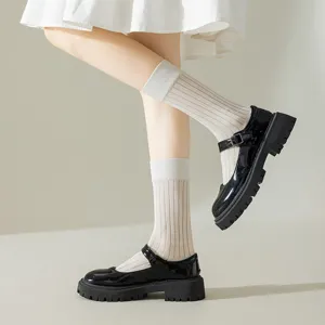 Japanese style women ribbed mid calf socks paired with black patent leather Mary Jane detail.