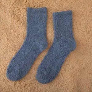 Close-up detail shot of fuzzy coral fleece winter warm mid-tube socks in solid grey color.