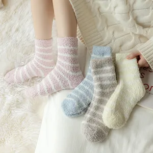 Close-up detail of cozy striped fuzzy fleece socks in multiple soft pastel colors for winter.