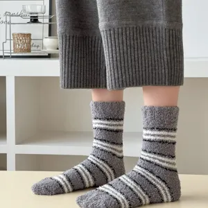 Close-up detail of soft grey striped coral fleece fuzzy socks, warm home sleep floor socks.